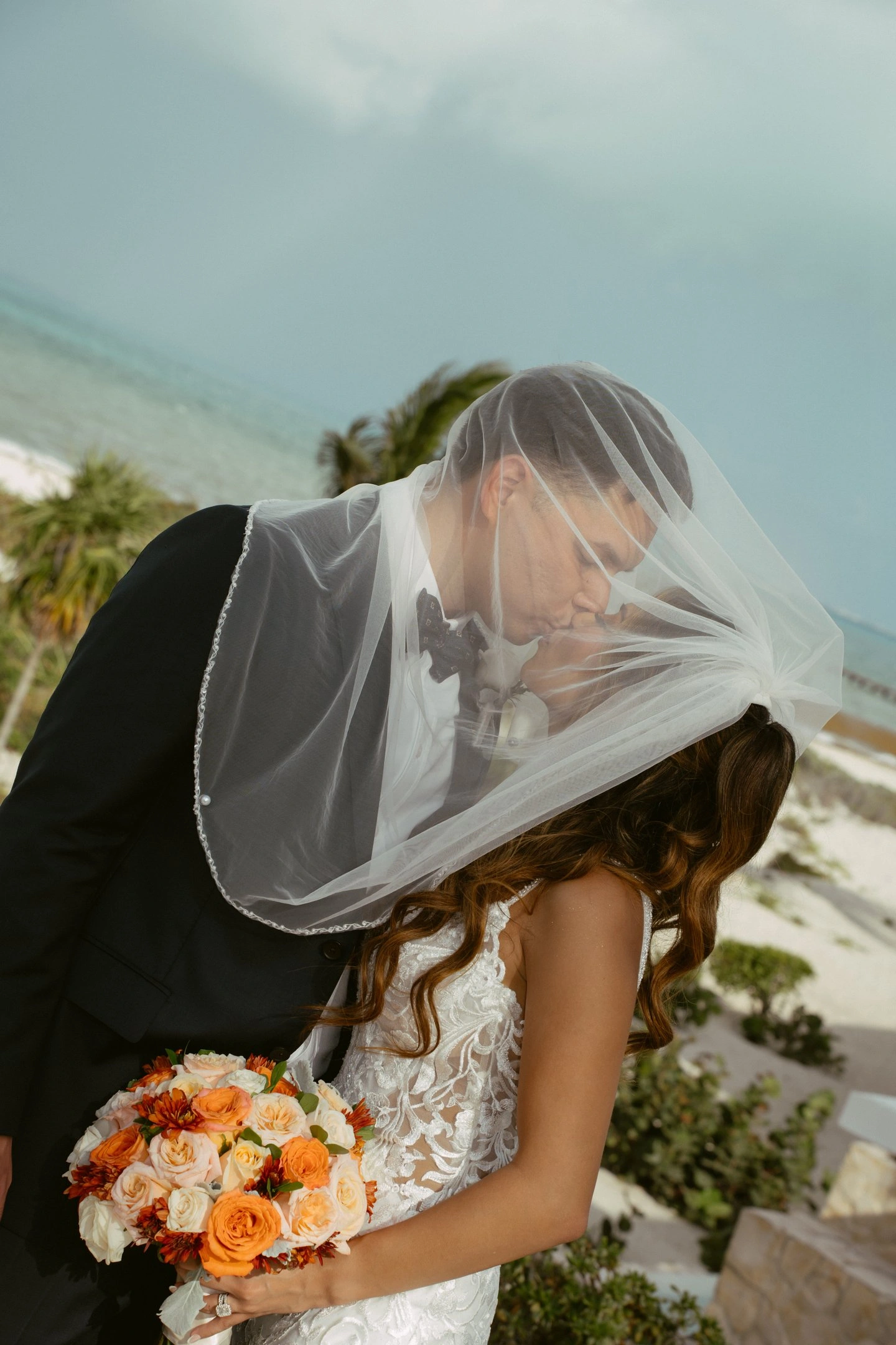 Pareja besándose bajo el velo de la novia